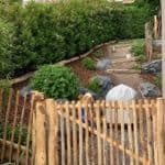 Franse rondhoutpoort van 150 cm breed bij 100 cm hoog als toegang naar een tuin