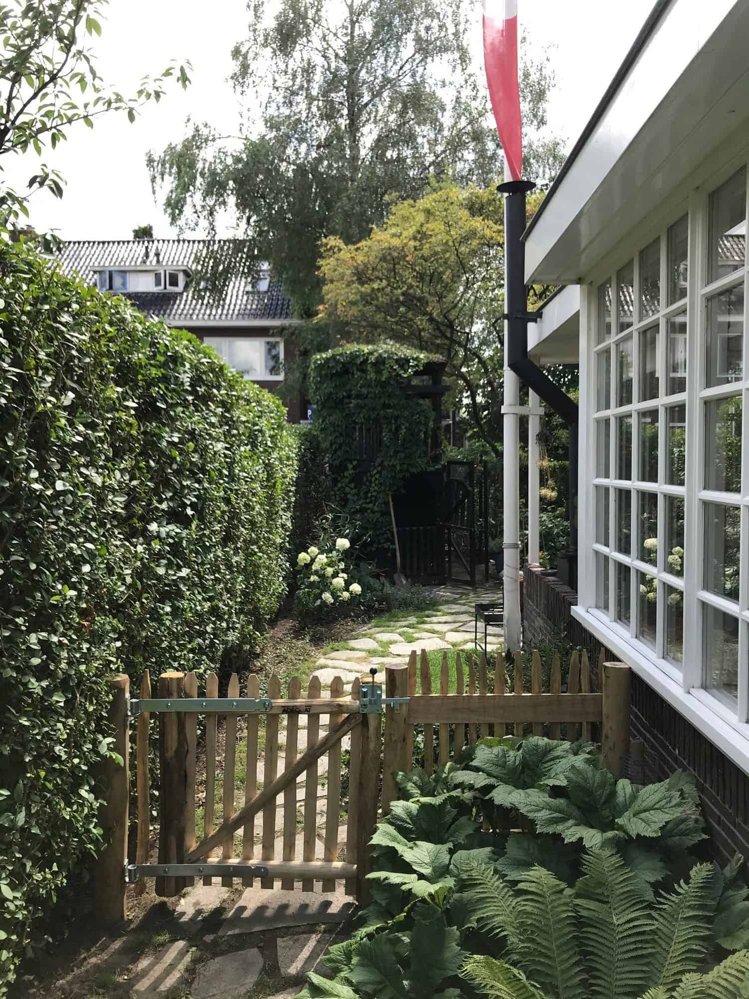 Franse rondhoutpoort van 80 cm bij 80 cm als doorgang naar een tuin