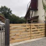 Eiken dubbele boerenlandhek op maat gemaakt. De poort staat rechts aan het huis vastgemaakt en dient als doorgang naar de parkeerplek en de achtertuin.