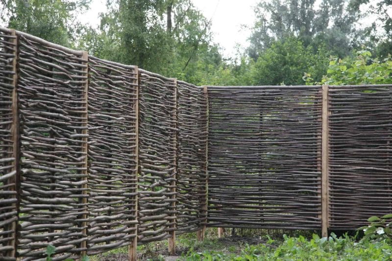 Hazelaarschermen Somme 1 gebruikt als natuurlijke afrastering in een tuin met veel groen
