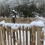 Frans schapenhek van 80 cm hoog met een latafstand van 4 cm en een franse rondhoutpoort van 80 cm bij 80 cm in een tuin met heel veel sneeuw