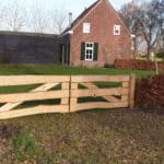 Dubbele kastenje boerenlandhek van 205 cm breed en 110 cm hoog met kastanje schaaldelen. Deze poort staat in de tuin aan de heg.