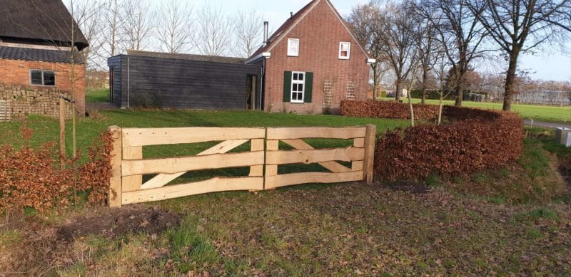 Dubbele kastenje boerenlandhek van 205 cm breed en 110 cm hoog met kastanje schaaldelen. Deze poort staat in de tuin aan de heg.
