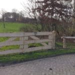 Dubbele kastenje boerenlandhek van 205 cm breed en 110 cm hoog met kastanje schaaldelen. Deze poort staat aan het begin van de wei als toegangspoort.