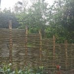 Schutting van wilgentenen met kastanjehouten palen