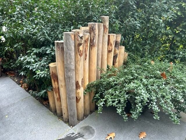 Afscheiding in tuin van kastanjehouten palen in verschillende hoogte met een diameter van 7-9 en 10-12 cm