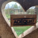 Close up Adéquat logo plankje in uitgesneden houten hart